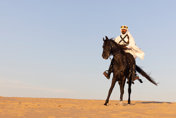 Wall Mural - Saudi man in a desert with his horse