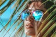 beautiful woman close up portrait with palms reflections in sunglasses, summer or spring break vibes