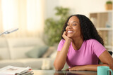 Fototapeta Pomosty - Happy black woman resting and smiling at home