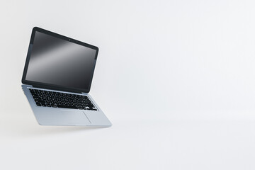 Open silver laptop floating on white background, technology and design concept. 3D Rendering