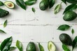 a group of avocados and leaves on a white surface