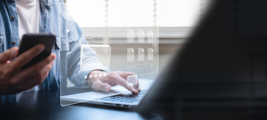 Fototapete - Document management system concept, Businessman using a laptop computer and smartphone at the office after being set up by an IT specialist. Software for corporate file archiving