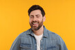 Portrait of handsome man laughing on yellow background