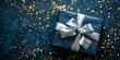 Blue gift box with a silver ribbon on a dark blue background with golden confetti.