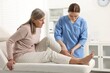 © New Africa - Arthritis symptoms. Doctor examining patient's leg in hospital