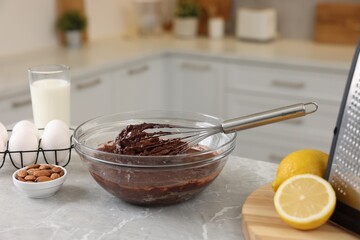 Wall Mural - Metal whisk, chocolate cream in bowl and different products on gray marble table indoors