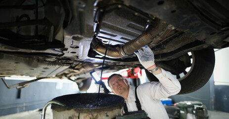 Wall Mural - Man repairman fixing car in workshop closeup. Auto service concept