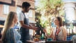 © Gorodenkoff - Two Female Friends Ordering Delicious Cake Desserts From a Member of the Staff in a Cafe. Handsome Multiethnic Waiter Holding a Terminal, Female Using Her Smartphone for a Contactless NFC Payment