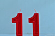 close up on red number eleventh birthday candle on a white background.
