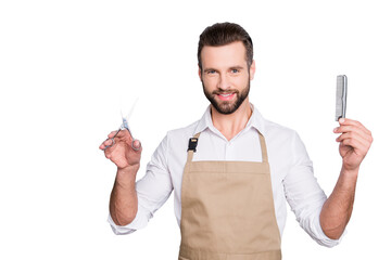 Poster - Portrait of cheerful, joyful barber with stubble in shirt having scissors, tools, equipments, comb in hands looking at camera isolated on grey background