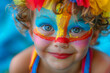 © Nataliia_Trushchenko - girl with blue eyes and a clown face paint, wearing a colorful outfit and a rainbow hat. A small child with bright makeup on his face and a playful, personifying the spirit of a carnival or holiday