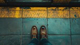 Fototapeta  - Person's feet behind yellow line of a subway platform.