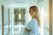 Expectant mother in hospital hallway, pregnancy monitoring, obstetrician's clinic.