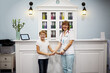 Female doctor and boy stand holding hands at reception desk