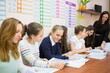 © Pavel Losevsky - Young teacher is giving a task to her seven students in classroom