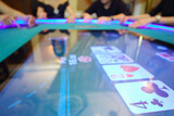 Fototapeta Perspektywa 3d - Electronic table in modern casino and hands of four players out of focus