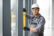 © Serhii - The worker installs a window frame in the room