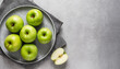 top view of green apples on grey plate, copy space