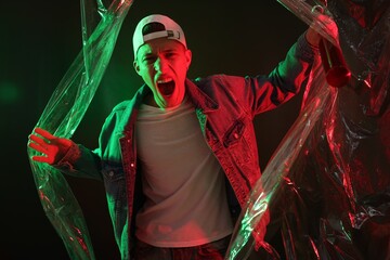 Poster - Young man with baseball bat on dark background in neon lights