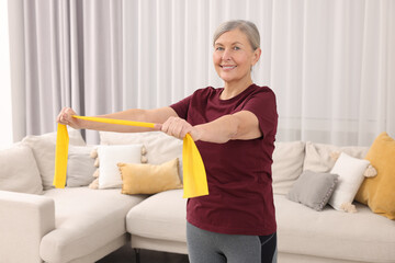 Sticker - Senior woman doing exercise with fitness elastic band at home