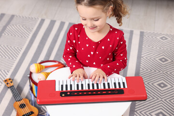 Poster - Little girl playing toy piano at home