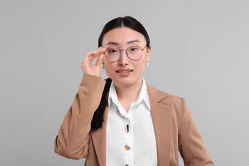 Poster - Portrait of smiling businesswoman on grey background