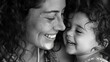 A black and white photograph captures a tender moment between a smiling mother and her laughing child, filled with joy and love.