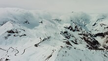 Aerial around view of Grossgloknershtrasse in snow. Great high mountain road near Grossglokner mount in Austrian Alps, 4k
