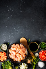 Wall Mural - Chicken stir fry with vegetables cooking ingredients at black background. Flat lay with copy space.