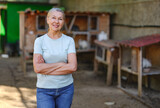 Fototapeta Na ścianę - Adult woman farmer with white rabbits in her farm. The farmer takes care of the animals