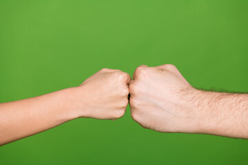 Wall Mural - Photo of two people hands palms touching fists showing conflict situation isolated green color background