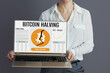 Woman employee showing laptop with bitcoin halving screen
