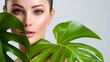 © Valua Vitaly - Beautiful woman with green leave near face and body.  Closeup girl's face with green leave. Skin care beauty treatments concept.