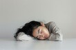 Tired Girl Sleeping on Elbows. Isolated on a white background, a young girl rests her head on her elbows, peacefully sleeping