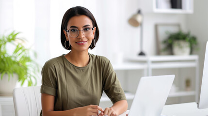 Wall Mural - Young woman is focused on working on her laptop in a modern office