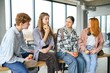 © Serhii - Cheerful students are sitting at desks and eating an apple during a break