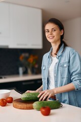 Wall Mural - Cooking Happiness: A Young Caucasian Housewife Joyfully Preparing a Fresh Vegetarian Salad in Her Modern Kitchen