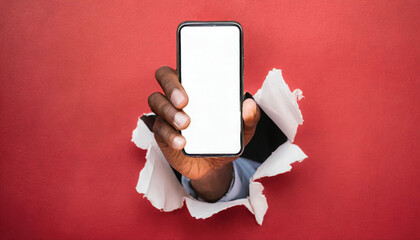 Hand holds a smartphone with white display breaks through a red wall. Concept of message, announce