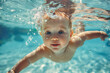 Baby swimming underwater in the pool.