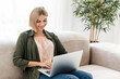 © InsideCreativeHouse - Relaxed caucasian young woman in casual clothes using laptop for online shopping at home. Freelancer student typing on laptop computer, watching movie, series, webinar