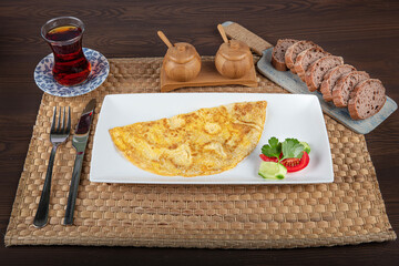 Wall Mural - Omelet with vegetable salad. closeup of a plate with a typical tortilla de patatas, spanish omelet, on a set table.