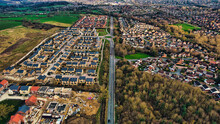 Aerial View Of A Suburban Housing Development With Rows Of Houses, Contrasting Undeveloped Land, And Streets In Harrogate, North Yorkshire.