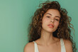 Curly-Haired Young Woman Posing on Teal Background, Casual Style
