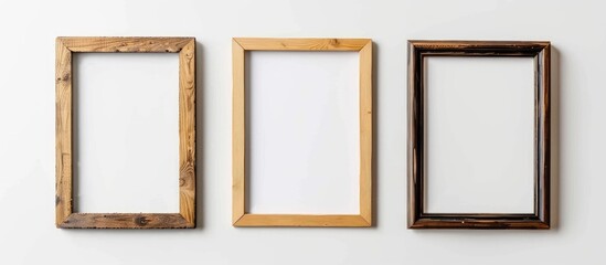 Sticker - Three picture frames made of wood are mounted on a white wall, showcasing a sense of symmetry and artistry with their rectangular shape and various tints and shades