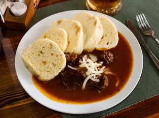 Wall Mural - Tasty dumplings (knedliky) served in Prague pub with beef stewed in gravy. Traditional Czech dish