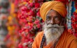 vecchio uomo indiano dalla barba bianca con turbante arancione su uno sfondo di fiori