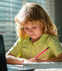 Fototapete - Kid boy at home writes draws, classes for a child at home. Homeschool school boy doing homework and learning at class. Child hold a pencil and draw at home. Schoolboy teen drawing sitting at table.