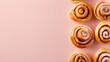 baked cinnamon rolls pastries on side of pastel colored cream background with copy space, top down view