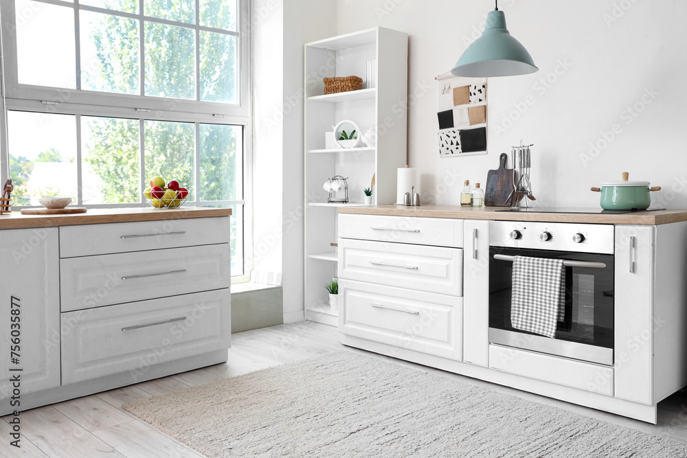 Interior of kitchen with white counters and oven