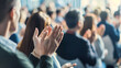 © Nawarit - An audience applauding for a speaker at a business and technology conference, the enthusiastic applause, and the conference room's modern design.